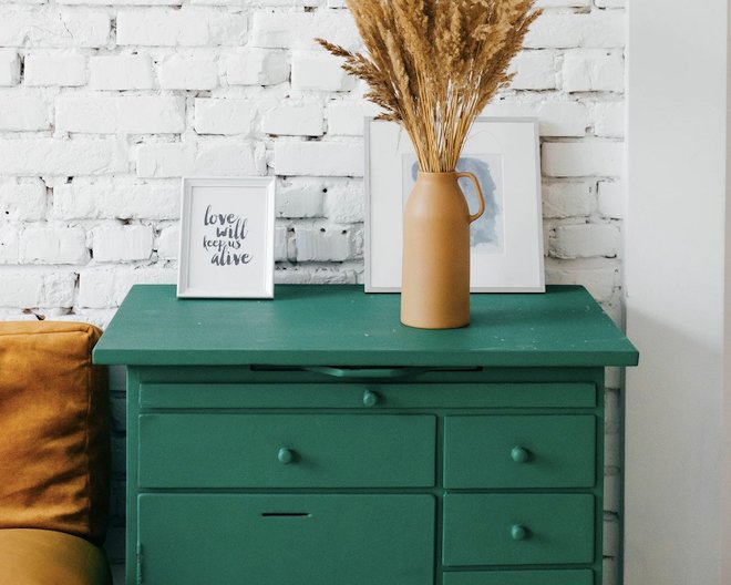 green drawers with a plant and picture on top with the quote love will keep us alive